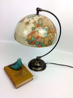 a small globe lamp with a book next to it