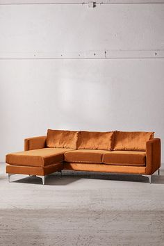 an orange couch sitting on top of a white floor