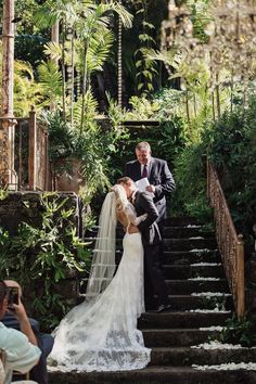 a bride and groom are kissing on the steps