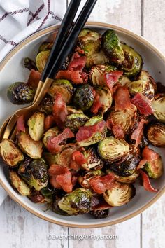 a bowl full of brussel sprouts and bacon with chopsticks