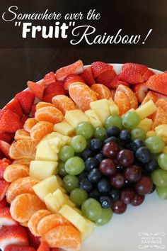 a cake with fruit arranged in the shape of a rainbow