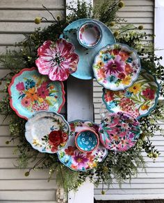 a wreath made out of plates and flowers