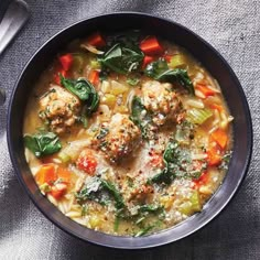 a bowl of soup with meatballs and vegetables