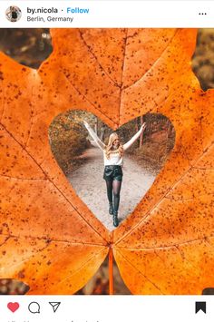 a woman standing in front of a heart shaped leaf