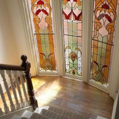 the stairs lead up to three stained glass windows in this home's entryway