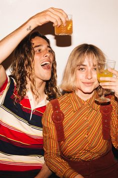 two people are drinking beer and smiling at the camera