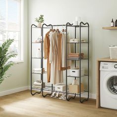 a laundry room with an iron rack and clothes