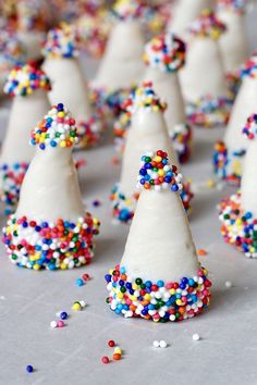 there are many white cones with sprinkles on them