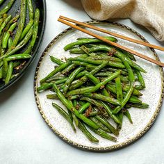 green beans on a plate with chopsticks in the middle and text overlay reading healthy stir - fried side dish chinese garlic green beans