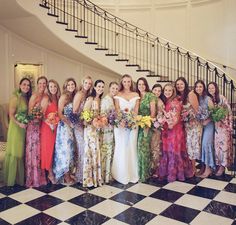 a group of women standing next to each other in front of a spiral stair case