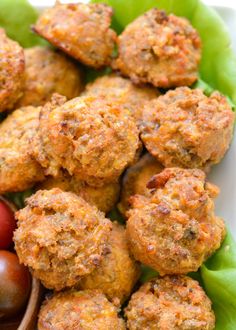 some meatballs are sitting on top of lettuce leaves and cherry tomatoes in a bowl