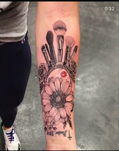 a woman's arm with makeup brushes and flowers on it