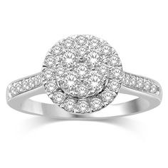 a white gold ring with two round diamonds on the band and an oval shaped halo