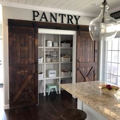 a kitchen with an open pantry door and counter top next to a bowl of fruit