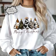 a woman wearing a white sweatshirt with christmas trees on it and the words merry christmas