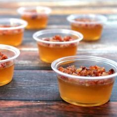 small plastic cups filled with food on top of a wooden table