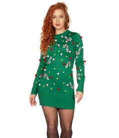 a woman wearing a green sweater dress with candy canes on it