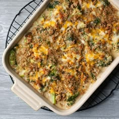 a casserole dish with broccoli, cheese and other toppings on a wire rack