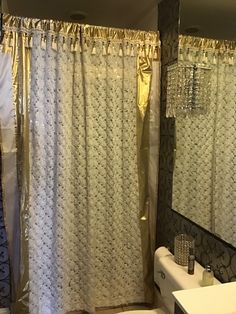 a white sink sitting under a bathroom mirror next to a bathtub and shower curtain