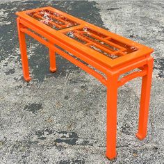 an orange table sitting in the middle of a parking lot with no one around it