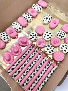 pink and white decorated cupcakes in a box with polka dots on the top