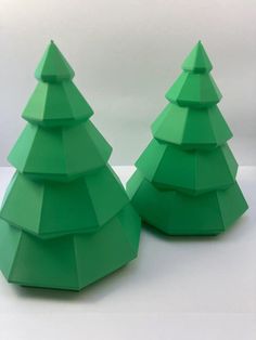 two green paper christmas trees sitting next to each other