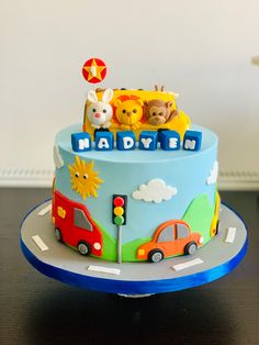 a birthday cake with cars and teddy bears on top