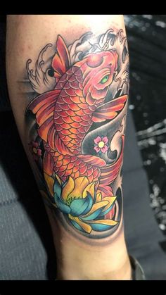 a person with a tattoo on their leg has a koi fish in the water