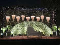 an outdoor seating area decorated with lights and greenery