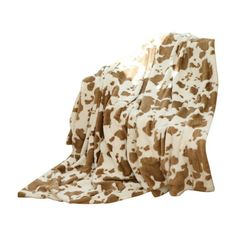 a cow print blanket sitting on top of a white floor covered in brown and white spots