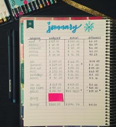 a notebook with a calendar on it next to some pens