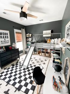 a bedroom with a black and white checkered floor, bunk bed, desk, chair, bookshelf and play area