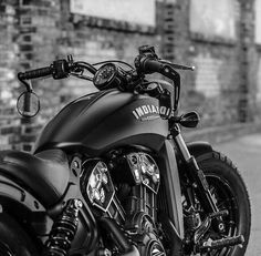 a black motorcycle parked in front of a brick building