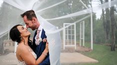 a bride and groom standing under a veil