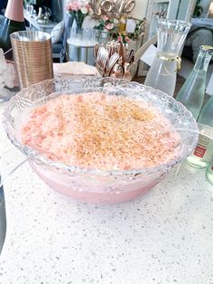 a bowl filled with food sitting on top of a counter next to bottles and vases