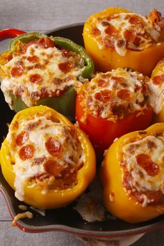 several stuffed peppers in a pan with cheese on top