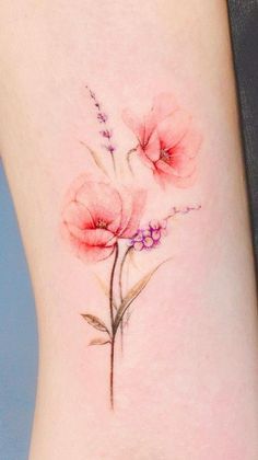 a close up of a flower on the side of a woman's leg with pink flowers