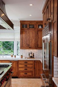 a kitchen with wooden cabinets and marble counter tops