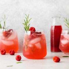 two glasses filled with raspberry punch and garnished with rosemary