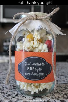 a jar filled with popcorn sitting on top of a table