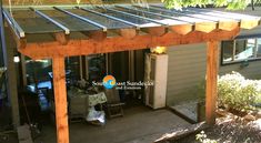 a wooden pergoline covered patio next to a house