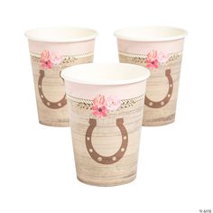 three paper cups with horseshoes and flowers painted on the side, one is pink