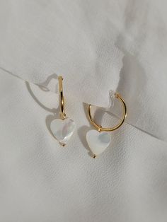 These dainty earrings are made with freshwater shell heart pearls and 18 karat gold plated hoops. This plating protects against wear and tear, tarnishing, and light contact with substances such as water. All earrings are handcrafted with care and custom made to meet your unique needs. Closure options: * Pierced closures are hypoallergenic and nickel free. * Clip on closures are made of acrylic/plastic which makes for an invisible look. They are also hypoallergenic and nickel free. How to wear clip ons: Hold the front of earring in one hand while pulling the clear closure open with the other hand, place the earring onto the thin upper earlobe, then slide the earring down the earlobe to secure in place. Please feel free to message me for any questions! Shell Heart, Freshwater Pearl Drop Earrings, Clear Earrings, Heart Hoop Earrings, Dangle Hoop Earrings, Earrings Heart, Hoop Earrings Gold, Heart Drop Earrings, Pearl Hoop Earrings