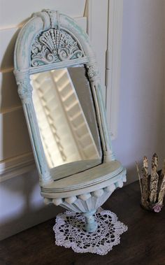 an old fashioned mirror on top of a table