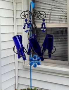 a blue chandelier hanging from the side of a window in front of a white house