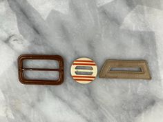 There are 3 belt buckles in this listing. 2 are completely covered, front & back in leather: 1.5" x 2.5" rectangle with metal rod in the middle 1.25" x 2.75" trapezoid, with an opening in the middle. Bakelite circle measures 1 3/8" round. These are perfect to complete vintage costumes. Could also be used as slides on scarves. Retro Adjustable Belt Buckles With Antique Buckle, Retro Adjustable Antique Belt Buckle, Vintage Belts With Rectangular Antique Buckle, Vintage Belt With Antique Buckle, Rectangular Antique Brown Belt Buckles, Vintage Rectangular Leather Belt Buckles, Scarf Slides, Vintage Belt Buckles, Vintage Belt