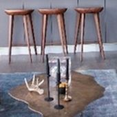 three wooden stools sitting on top of a rug