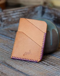 a leather wallet sitting on top of a wooden table