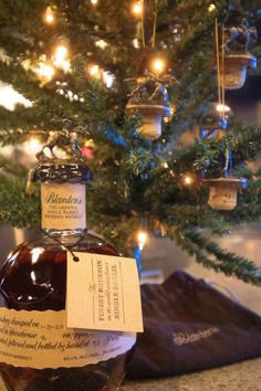 a bottle of brandy sitting next to a christmas tree