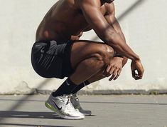 a shirtless man squatting down on the ground